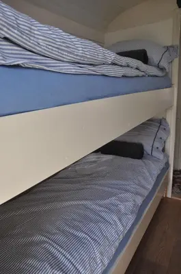 a bunk bed with a blue and white striped mattress at Gypsy Waggon - A villa on wheels in Amsterdam