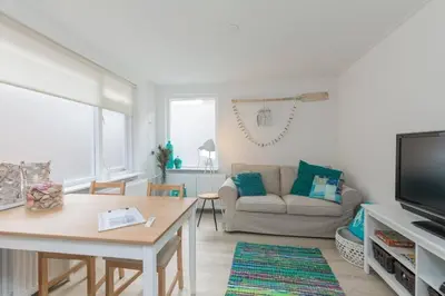 a living room with a couch and a table at Have a nice stay! - Salty Beachhouse in Noordwijk aan Zee