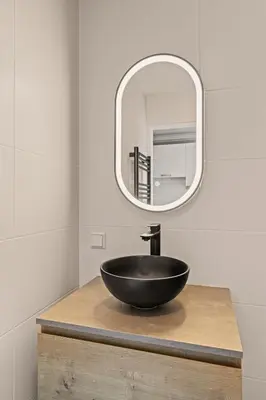 a bathroom with a black bowl sink and a mirror at Have a nice stay! - Salty Beachhouse in Noordwijk aan Zee