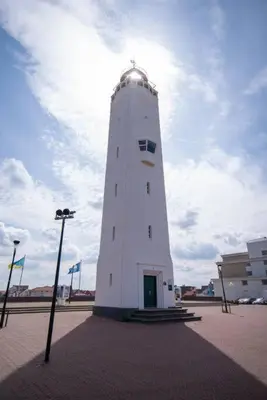a white lighthouse sitting in the middle of a street at Have a nice stay! - Salty Beachhouse in Noordwijk aan Zee