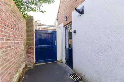 a blue door on a building with a brick wall at Have a nice stay! - Salty Beachhouse in Noordwijk aan Zee