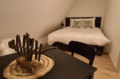 a bedroom with a bed and a black table with a table sidx sidx at B&B Het Groene Hart in Nieuwkoop