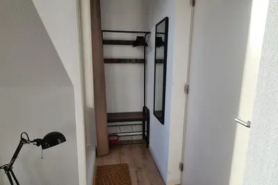 a hallway with a staircase with a mirror and a bike at B&B Het Groene Hart in Nieuwkoop