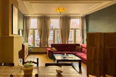a living room with a red couch and a table at Gunnery's Guest House in Alkmaar
