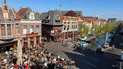 a group of people sitting at tables on a city street at Gunnery's Guest House in Alkmaar
