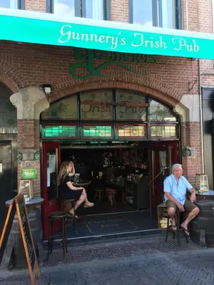 a man and woman sitting in front of a store at Gunnery's Guest House in Alkmaar
