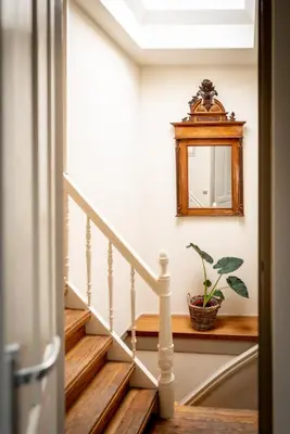 a stairway with a mirror and a plant at Gunnery's Guest House in Alkmaar