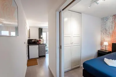 a bedroom with a blue bed and a kitchen at Studio Evership just minutes from the beach and center in Zandvoort