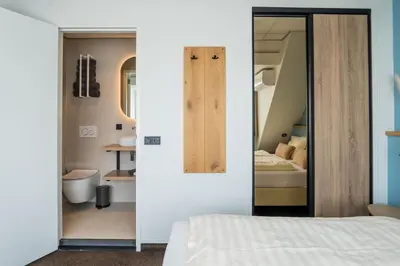 a bedroom with a bed and a bathroom at Huis 8 Studio's in Katwijk aan Zee