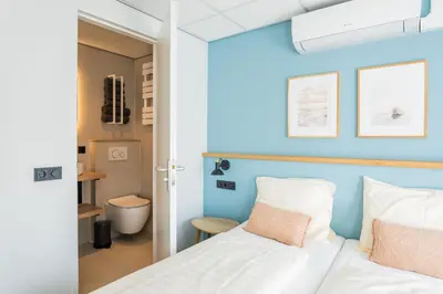 a bedroom with a bed with a blue wall at Huis 8 Studio's in Katwijk aan Zee