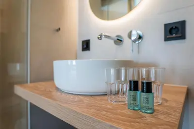 a bathroom counter with a sink and glasses on it at Huis 8 Studio's in Katwijk aan Zee