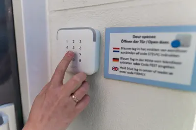 a woman is pressing a lightswitch with her hand at Huis 8 Studio's in Katwijk aan Zee
