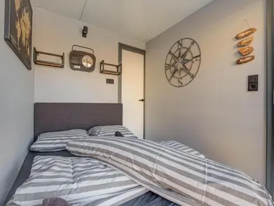 a bedroom with a bed and a clock on the wall at Houseboat in Volendam near Fort Edam in Volendam
