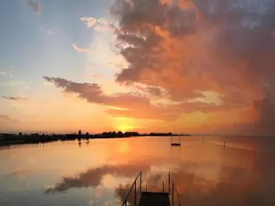 a sunset over a lake with a dock in the water at Houseboat in Volendam near Fort Edam in Volendam