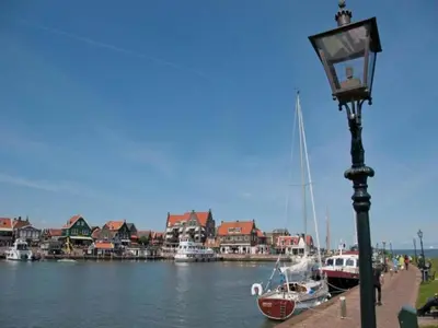 a street light next to a body of water with boats at Houseboat in Volendam near Fort Edam in Volendam