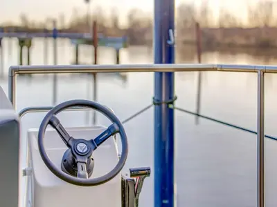 a steering wheel on a boat in the water at Houseboat in Volendam near Fort Edam in Volendam