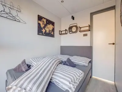 a bedroom with two beds and a clock on the wall at Houseboat in Volendam near Fort Edam in Volendam