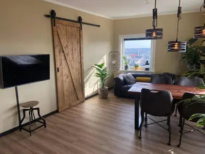 a living room with a table and a sliding barn door at Apartment Malisa in Zandvoort