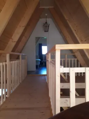 an attic with a wooden staircase in a house at A-frame volledig vrijstaande woning in Hensbroek