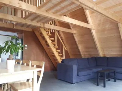 a living room with a blue couch and a table at A-frame volledig vrijstaande woning in Hensbroek