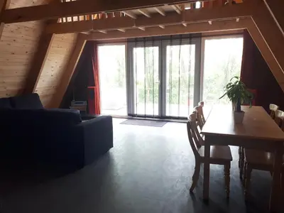 a living room with a couch and a table at A-frame volledig vrijstaande woning in Hensbroek