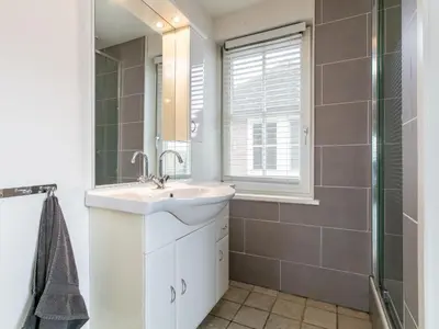 a bathroom with a sink and a shower at Zwaan 24-7 in Breukelen