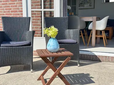 a blue vase sitting on a table next to two chairs at Zwaan 24-7 in Breukelen