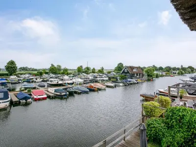a group of boats docked in a river at Zwaan 24-7 in Breukelen