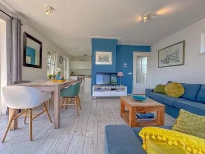 a living room with a blue couch and a table at Zwaan 24-7 in Breukelen