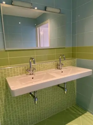 a bathroom with two sinks and a mirror at Tussen Tulp & Zee in Noordwijk