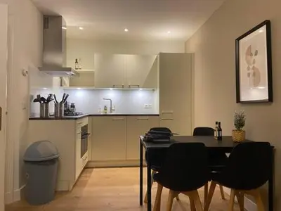 a kitchen with a table and chairs in a room at Tussen Tulp & Zee in Noordwijk