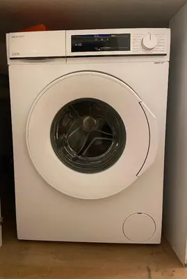a white washing machine with a microwave on top at Tussen Tulp & Zee in Noordwijk