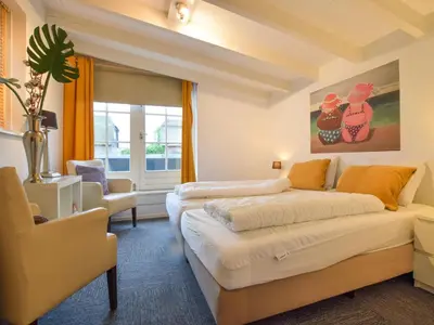 a bedroom with two beds and a couch at Zwaan 24-6 in Breukelen
