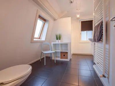 a bathroom with a toilet and a chair in it at Zwaan 24-6 in Breukelen