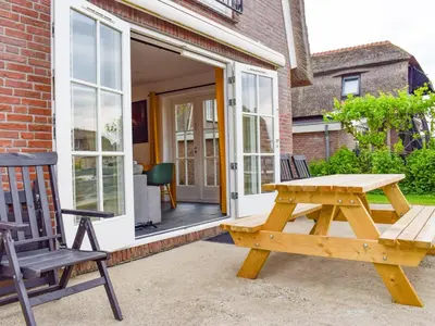 a wooden picnic table and a chair on a patio at Zwaan 24-6 in Breukelen