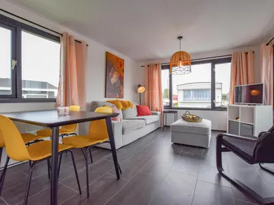 a living room with a table and yellow chairs at Blauwborst 24-24 in Breukelen