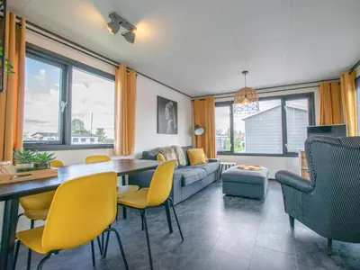 a living room with a table and yellow chairs at Blauwborst 24-20 in Breukelen