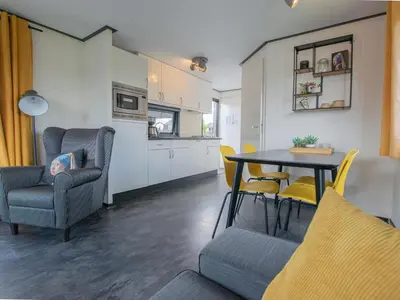 a living room with a table and chairs and a kitchen at Blauwborst 24-20 in Breukelen