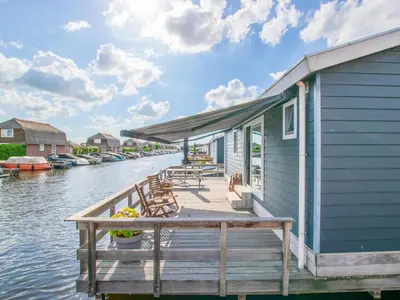a house on a dock on a body of water at Purperreiger 24-34 in Breukelen