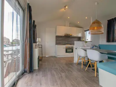 a kitchen with white cabinets and a table and chairs at Purperreiger 24-34 in Breukelen