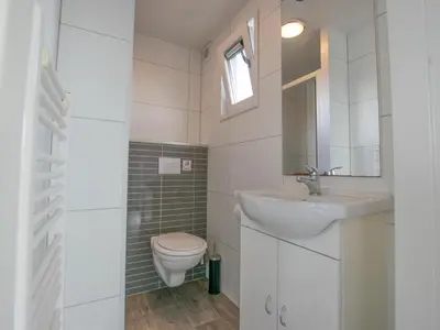 a white bathroom with a sink and a toilet at Purperreiger 24-34 in Breukelen