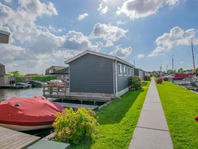 a house on the water with a boat next to it at Purperreiger 24-34 in Breukelen