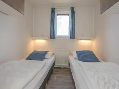 two beds in a small room with a window at Purperreiger 24-32 in Breukelen