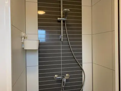 a shower with a hose in a bathroom at Purperreiger 24-32 in Breukelen