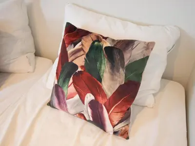 a pillow with a painting of flowers on a bed at Grote Karekiet 24-22 in Breukelen
