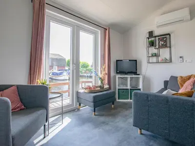 a living room with two couches and a large window at Grote Karekiet 24-22 in Breukelen
