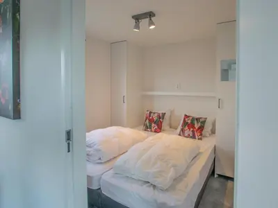 a bedroom with a bed with white sheets and pillows at Grote Karekiet 24-30 in Breukelen