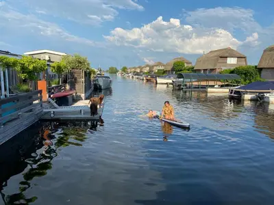 a person in a boat in the water with a dog at Grote Karekiet 24-30 in Breukelen
