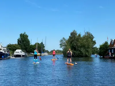 a group of people on paddle boards in the water at Grote Karekiet 24-30 in Breukelen
