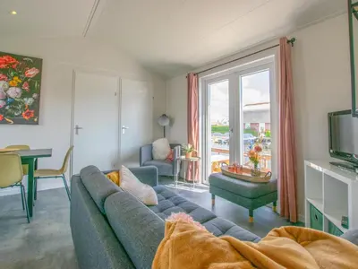 a living room with a blue couch and a window at Grote Karekiet 24-30 in Breukelen